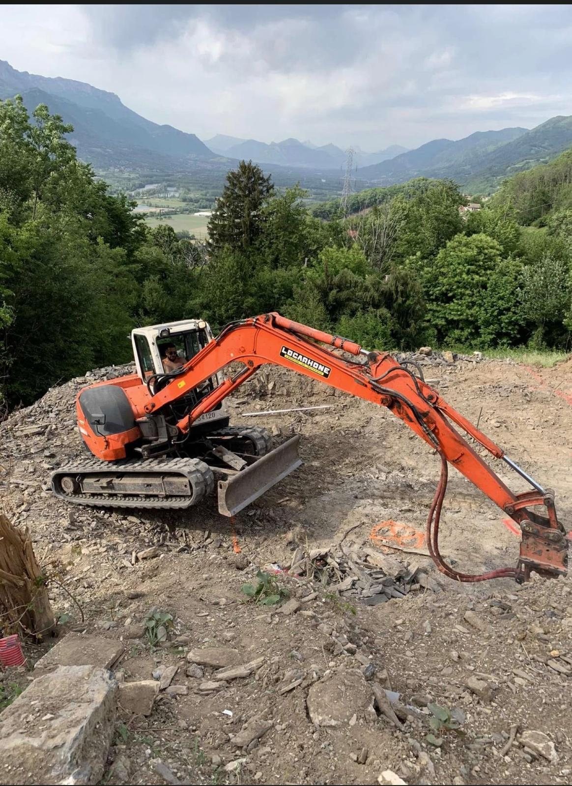 Pelle mécanique de MM Maçonnerie en terrassement sur un terrain en pente du Grésivaudan